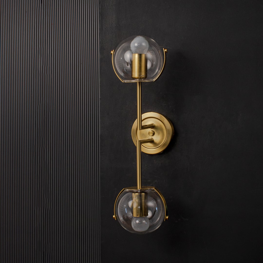 Contemporary wall light with double clear glass globes and gold metal frame designed for stylish bedroom living room and hallway decor.