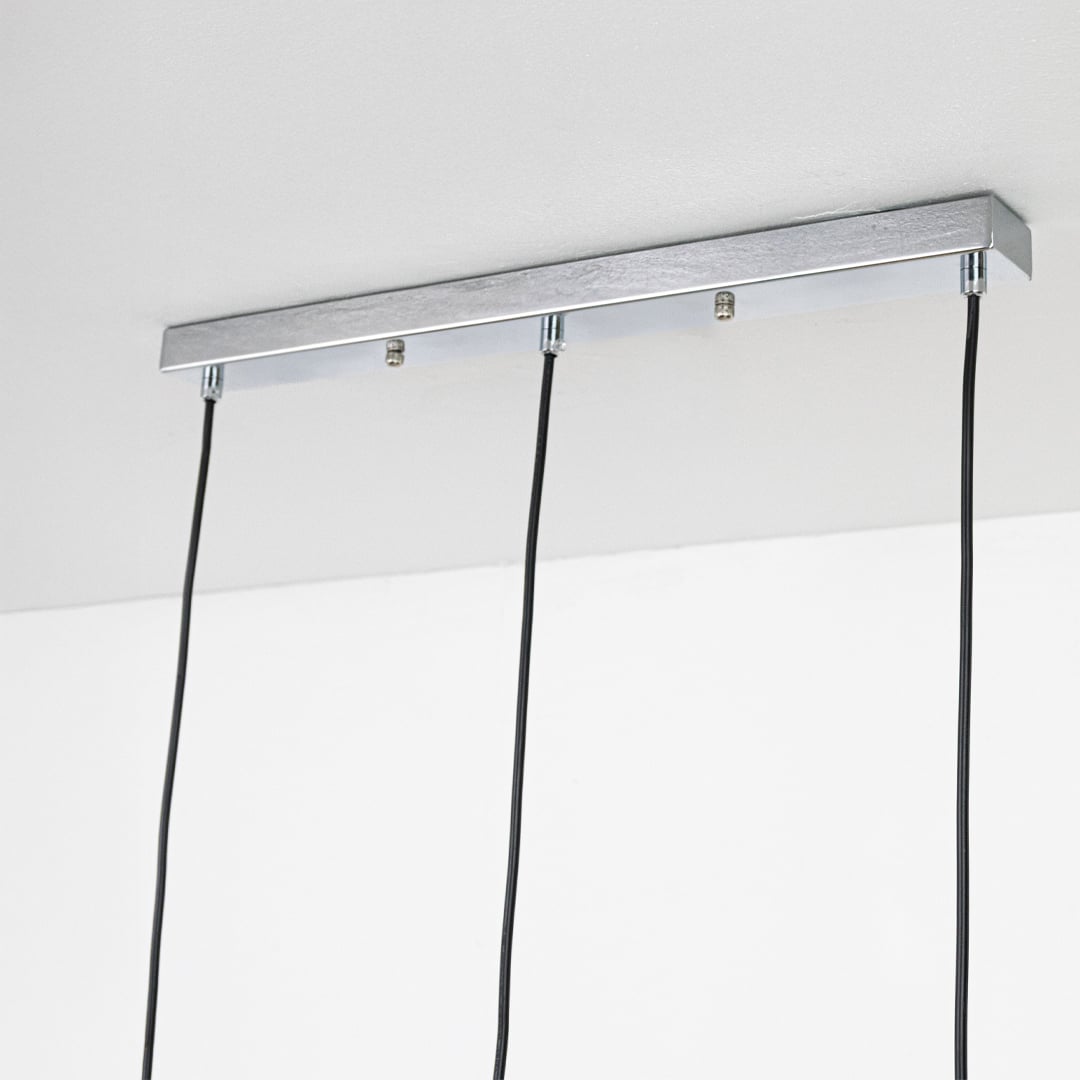 Closeup view of gold white and chrome pendant lights showing smooth metal texture and rounded shape for a bold modern decorative lighting accent.