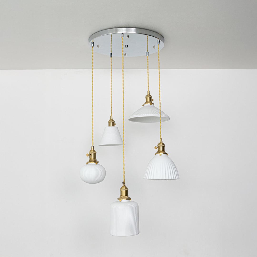 White ceramic pendant lights with ribbed and smooth shades and gold fittings displayed on a clean white background for clear product detailing.