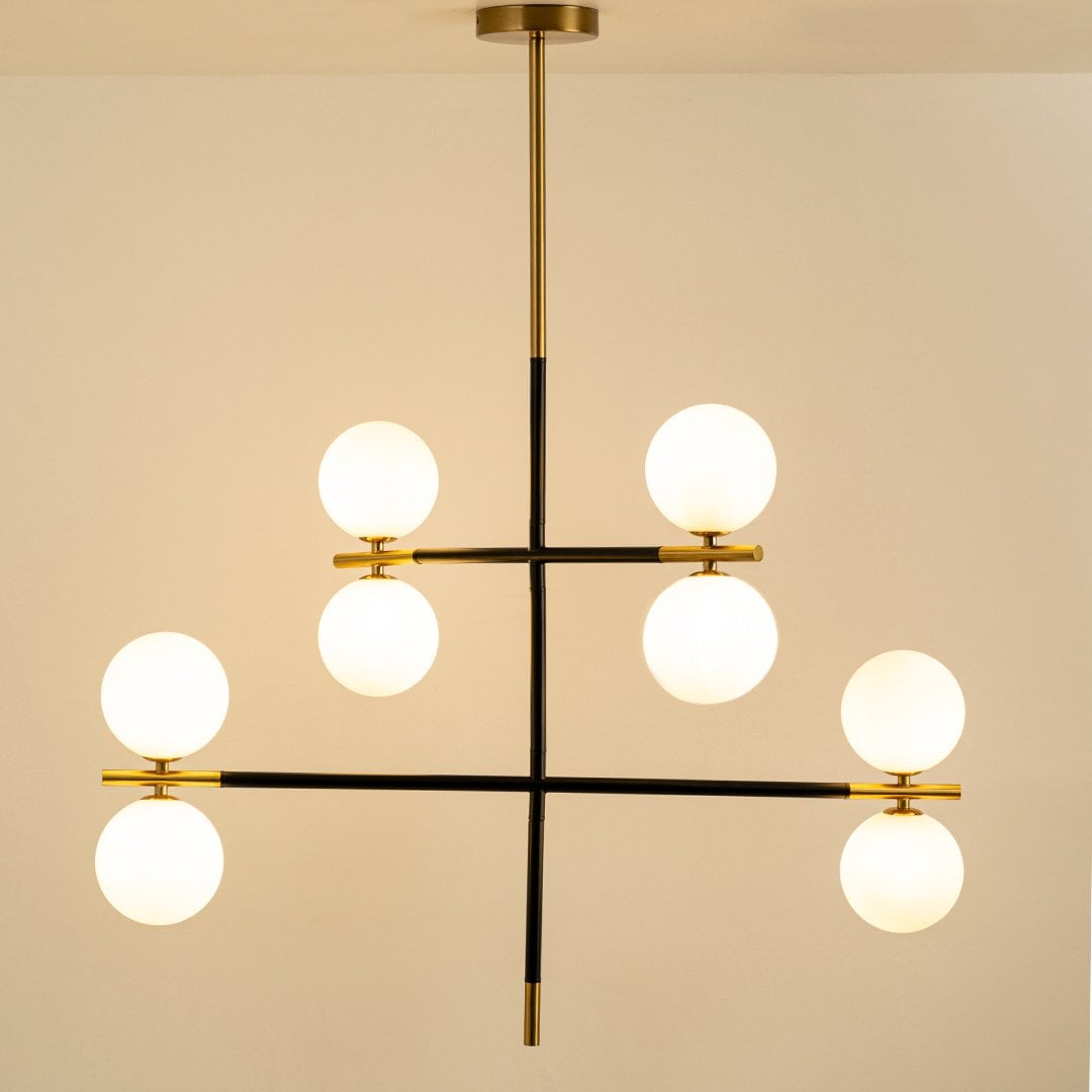 Contemporary chandelier with black frame and gold accents glowing elegantly on white background for modern living and dining rooms.
