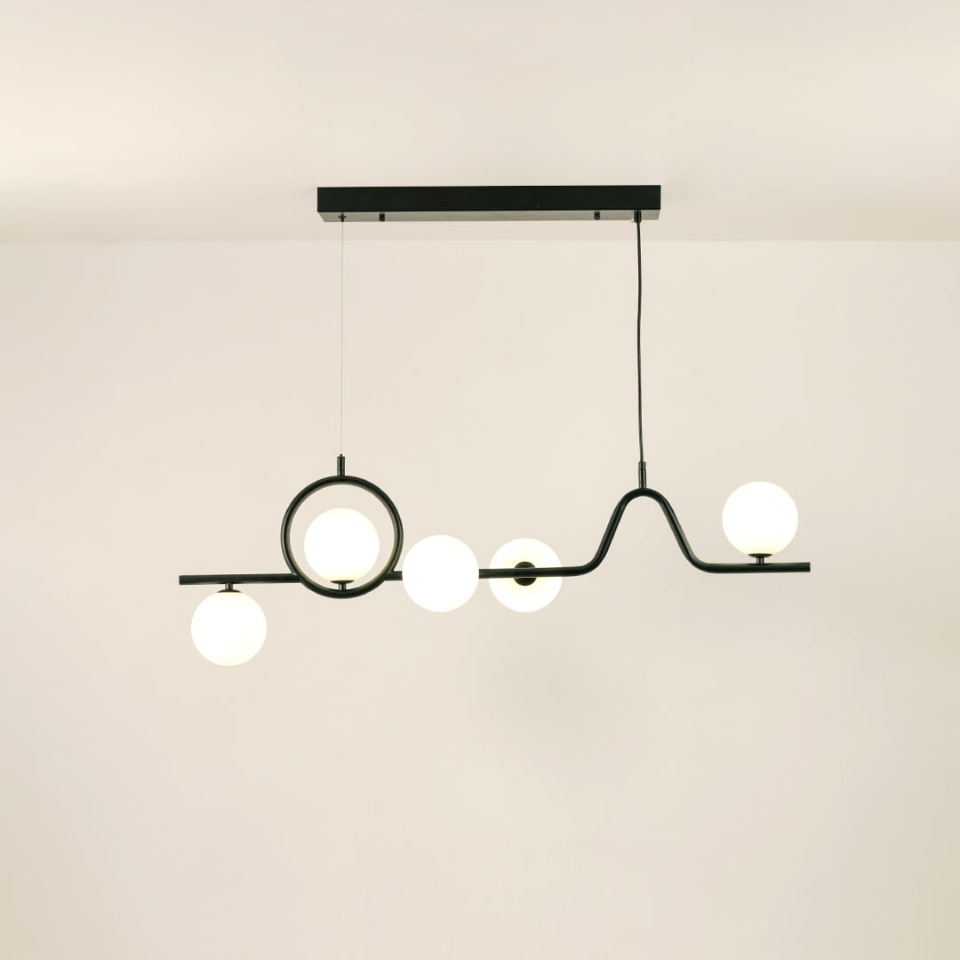 Black metal chandelier with glowing frosted glass globes on a clean white background showcasing its sculptural modern design.