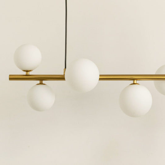 Closeup of gold metal chandelier showing smooth metallic frame frosted globes and refined contemporary craftsmanship.