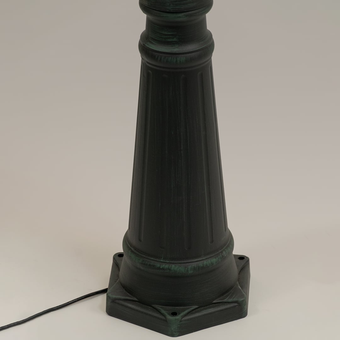 Closeup of tall outdoor lantern pedestal in black metal finish highlighting ribbed detailing and durable exterior craftsmanship.