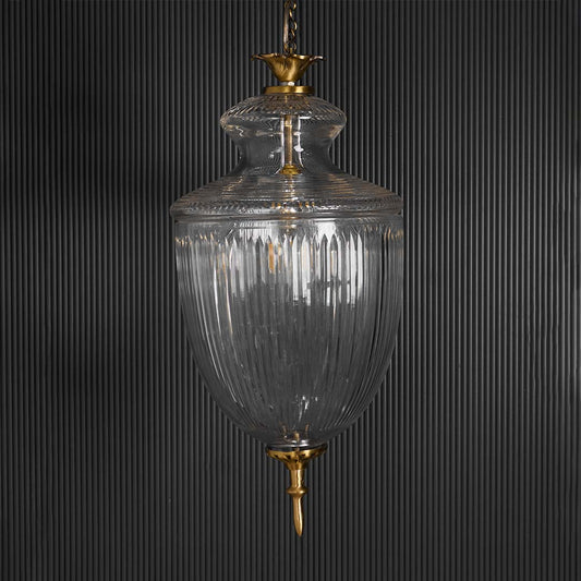 Vintage style hanging pendant light with clear ribbed glass shade and metal detailing displayed against a plain white background for product focus.