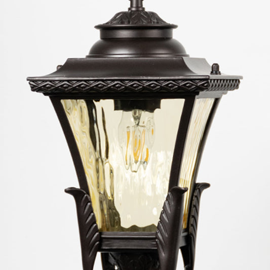 Closeup view of bronze hanging lantern light showing amber glass texture and elegant metal detailing.