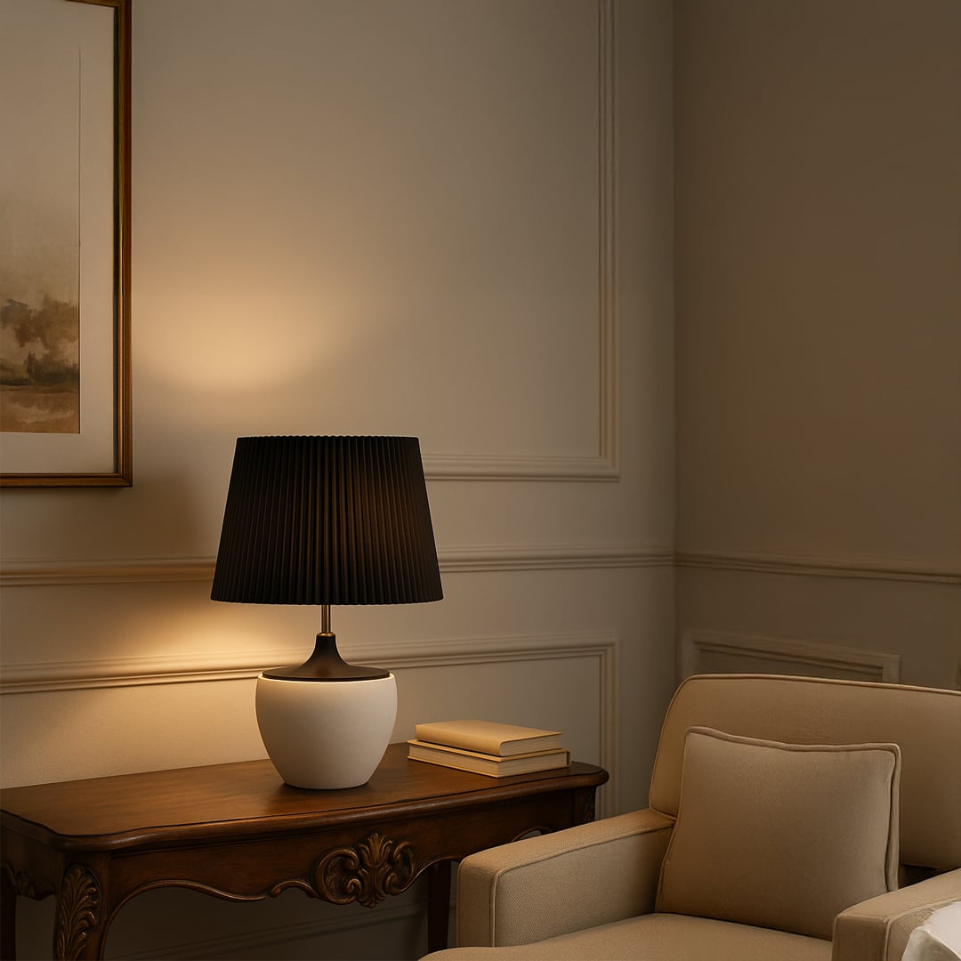 Modern black table lamp with pleated shade illuminating a cozy living room corner with a wooden console table and wall art.