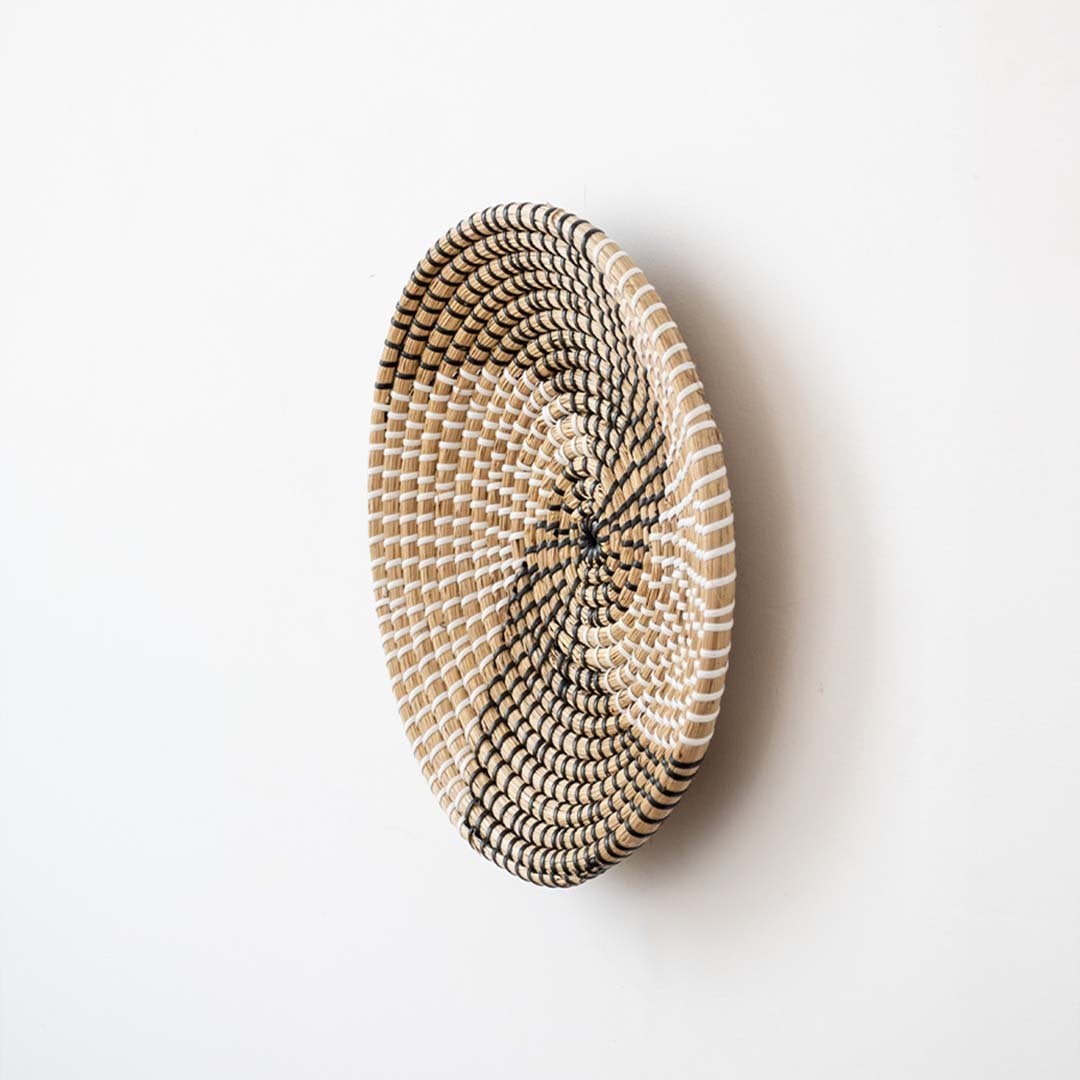 Side view of handwoven wicker basket wall decor showing spiral woven depth and natural texture for modern boho homes.