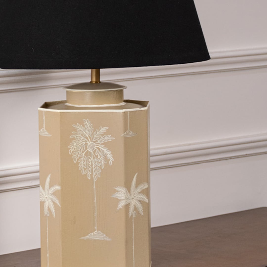 Closeup of palm tree table lamp showing fine white palm detailing on smooth beige ceramic base adding tropical elegance to contemporary decor.