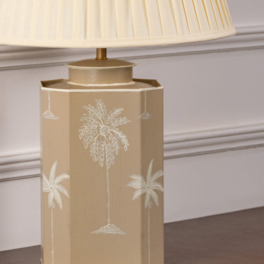 Closeup of palm tree table lamp showing detailed hand-painted palm design on beige ceramic base adding tropical charm to modern home interiors.