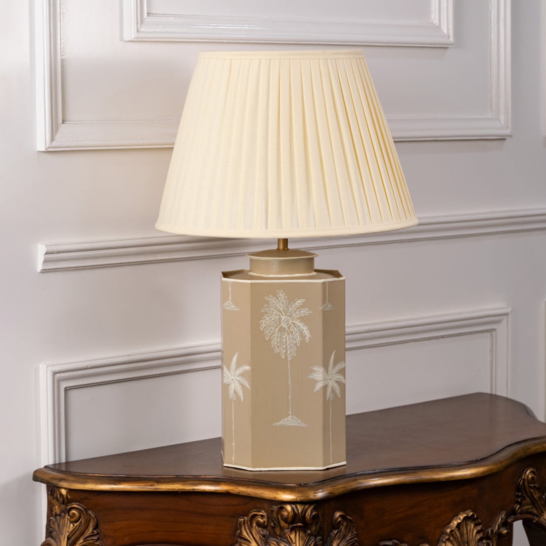 Palm tree table lamp turned off highlighting beige ceramic base with hand-painted white palm motifs and cream pleated shade ideal for bedside or hallway decor.