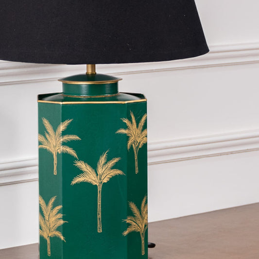 Closeup of green palm table lamp showcasing intricate golden palm detailing on rich green ceramic base adding luxury and tropical charm to contemporary decor.