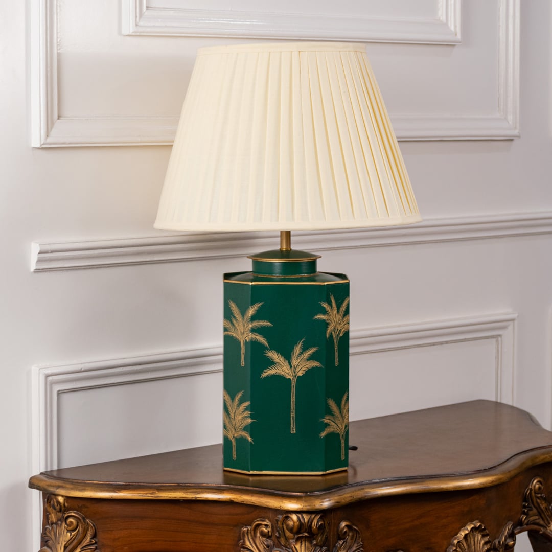 Green palm table lamp turned off showcasing glossy green ceramic base with gold palm tree design and cream pleated shade ideal for bedroom or living room interiors.