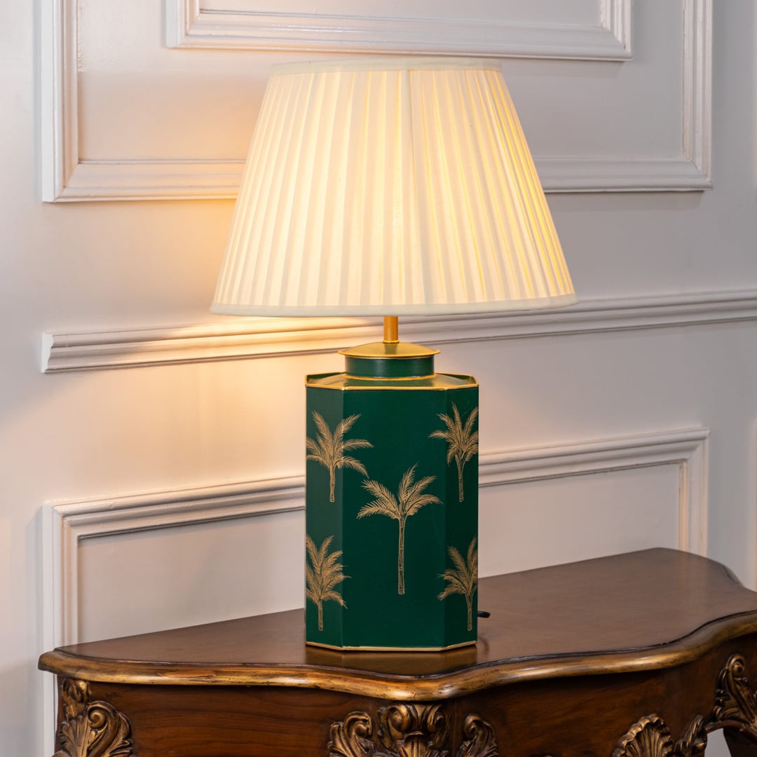 Green palm table lamp turned off showcasing glossy green ceramic base with gold palm tree design and cream pleated shade ideal for bedroom or living room interiors.