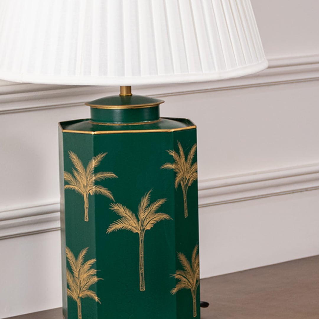 Closeup of green palm table lamp showing fine hand-painted golden palm detailing on rich green ceramic base adding tropical charm to premium interiors.