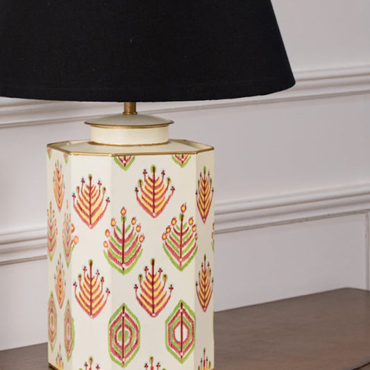 Close view of ceramic lamp base featuring detailed red and green hand painted motifs with a gold rim and cream background. The smooth finish and artistic craftsmanship reflect a blend of modern and ethnic design aesthetics.