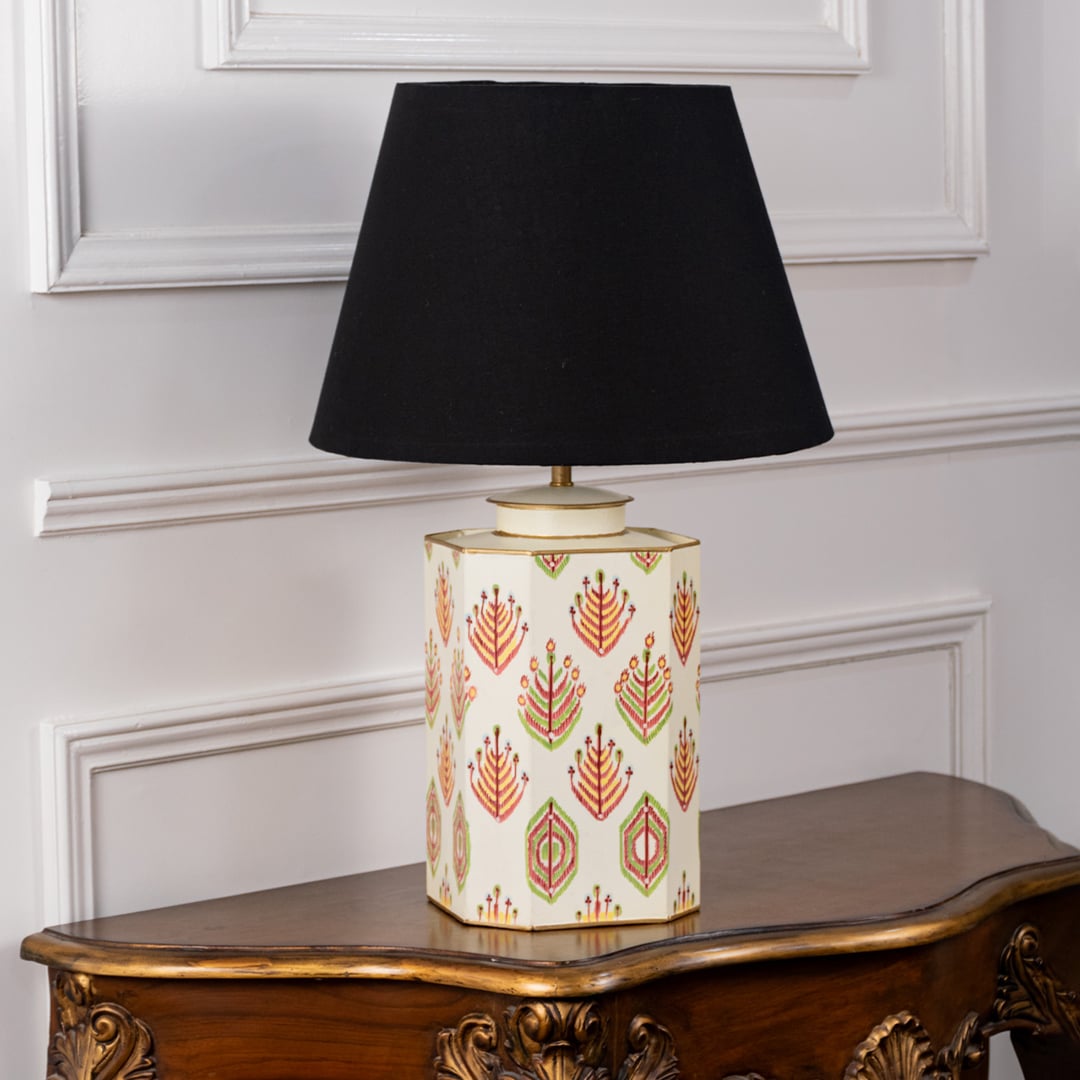 Ceramic table lamp with black shade displayed with lights off on a white background. The rich floral detailing and cream body enhance its timeless design making it perfect for living rooms bedrooms and study corners.