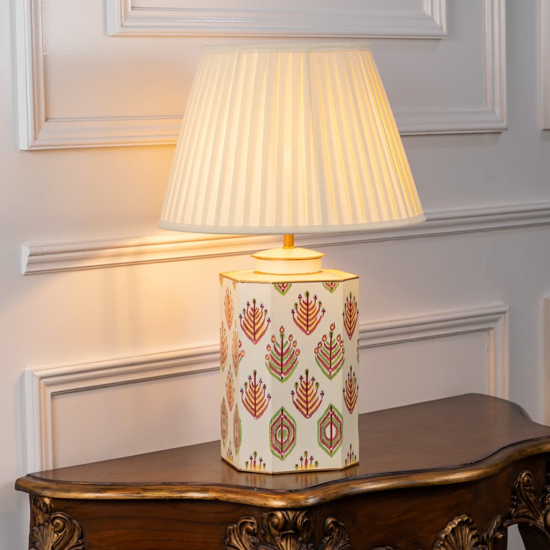Ivory tribal pattern table lamp turned on emitting a soft warm glow that enhances the colorful hand-painted tribal motifs and gives a cozy artistic look to modern interiors.