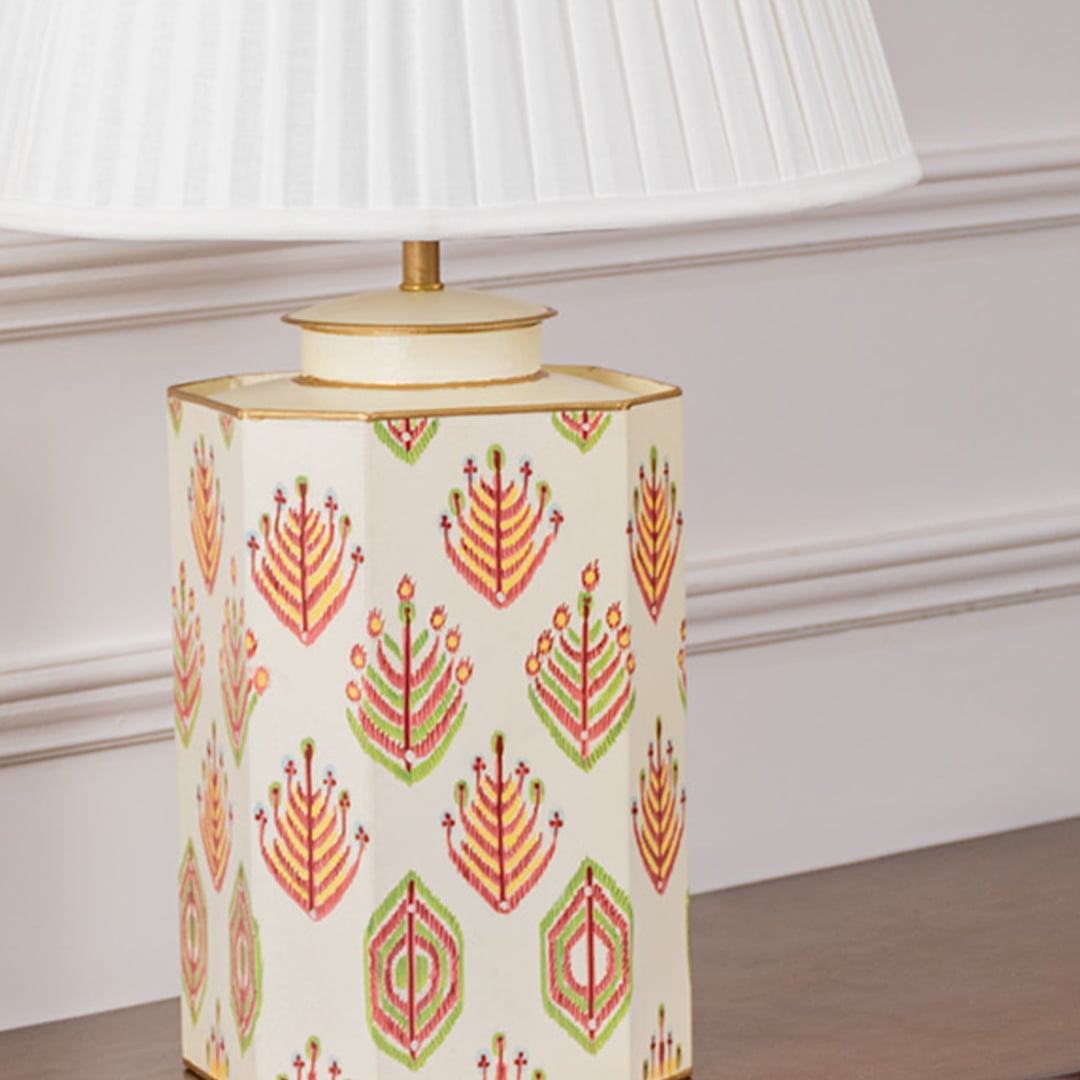 Detailed view of the ceramic lamp base featuring vibrant red and green floral motifs with a gold rim and smooth finish. The fine detailing and texture highlight its artisanal craftsmanship and premium quality design for stylish home interiors.