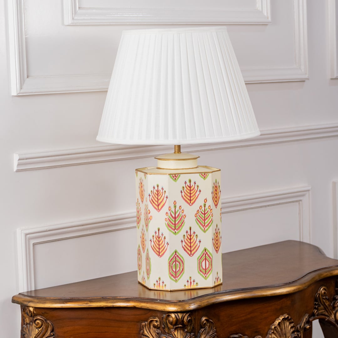 Ceramic table lamp with intricate floral pattern and pleated white shade displayed with lights off on a clean white background. The elegant design and vibrant colors stand out making it a perfect décor piece for modern and traditional spaces.