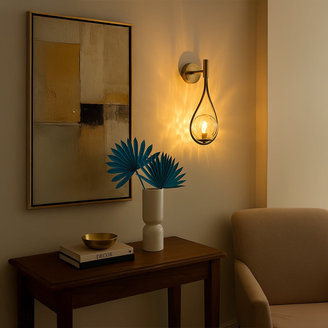Brushed gold teardrop wall light with hammered glass globe styled in a modern interior adding warm elegant lighting to living and bedroom spaces.