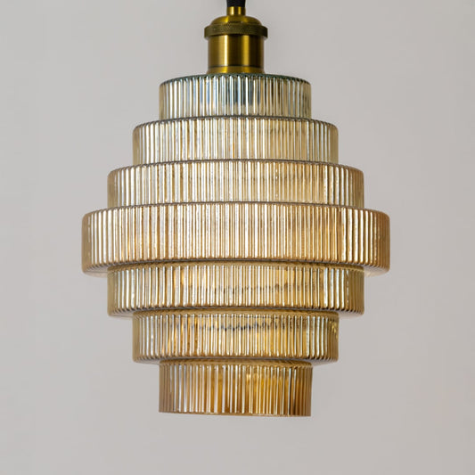 Closeup of the ribbed tiered glass pendant light showing detailed texture layered structure and warm illuminated glow.
