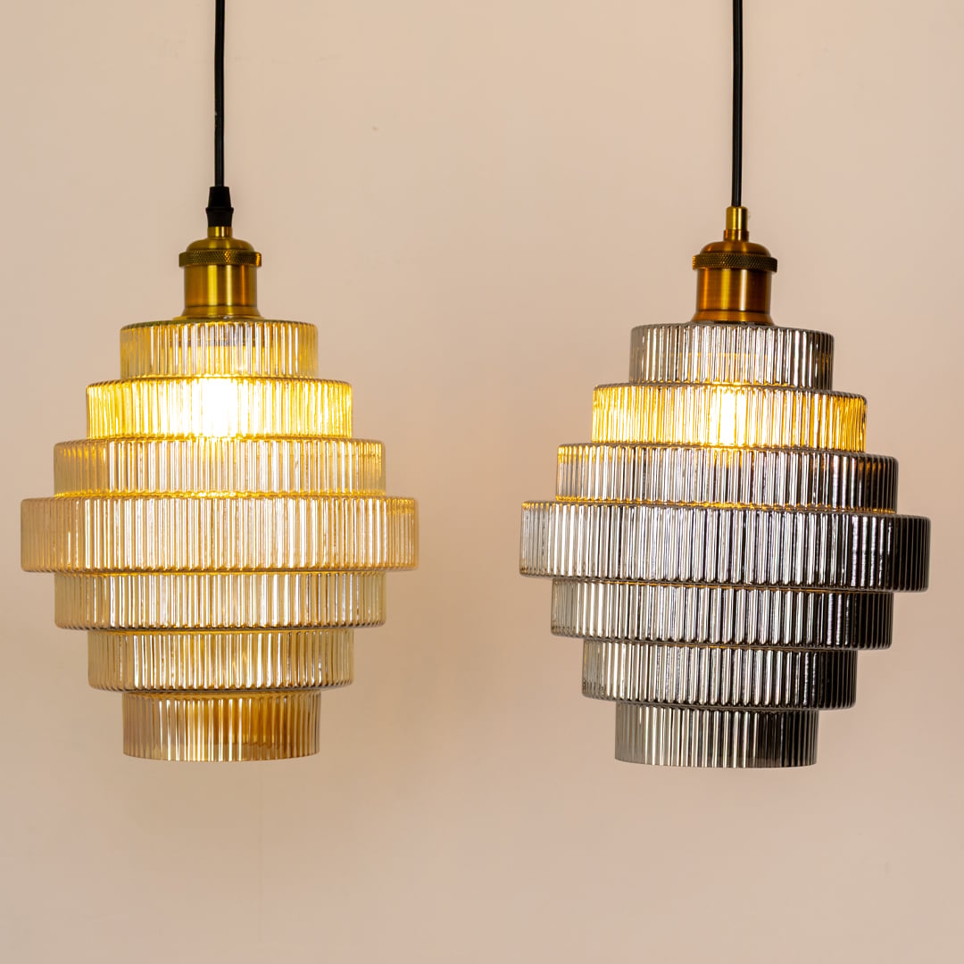 Grouped display of ribbed tiered glass pendant lights showcasing their layered design warm glow and elegant modern aesthetic.