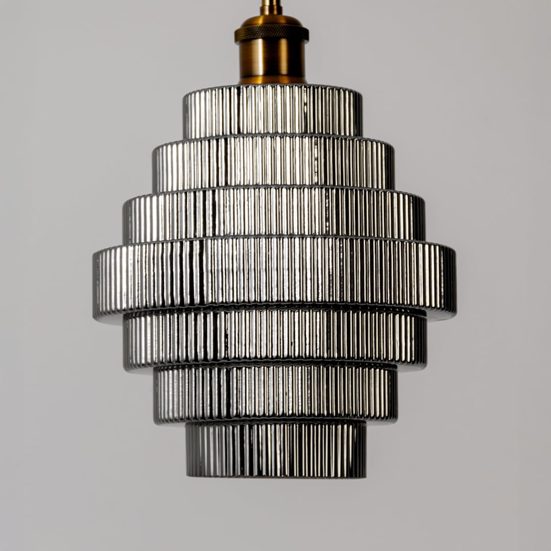 Closeup of the pendant light showing the detailed ribbed glass layers metallic accents and refined tiered structure with a modern finish.