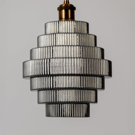 Closeup of the pendant light showing the detailed ribbed glass layers metallic accents and refined tiered structure with a modern finish.