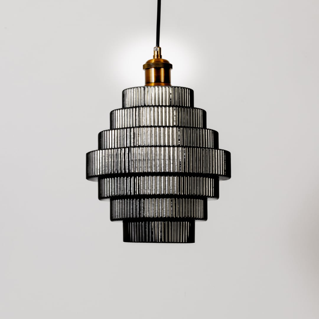 Pendant light with tiered ribbed glass layers shown turned off on a white background highlighting its structured modern form and texture.