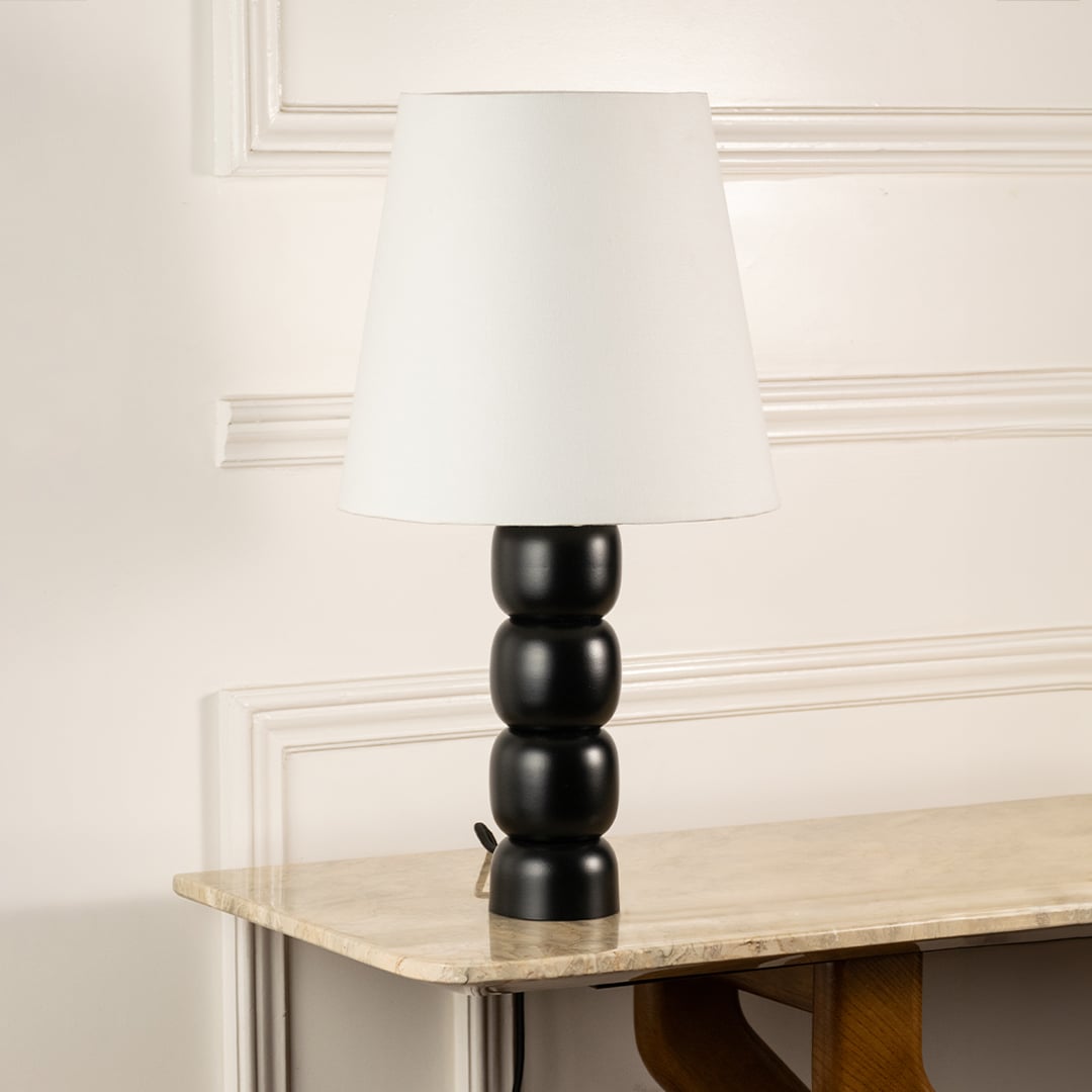Black stacked base table lamp with white shade shown switched off on a clean white background highlighting its modern elegant shape suited for interior decor.