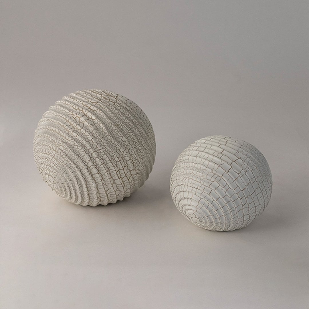 Decorative textured ceramic spheres in white finish styled together for modern home and tabletop accents.
