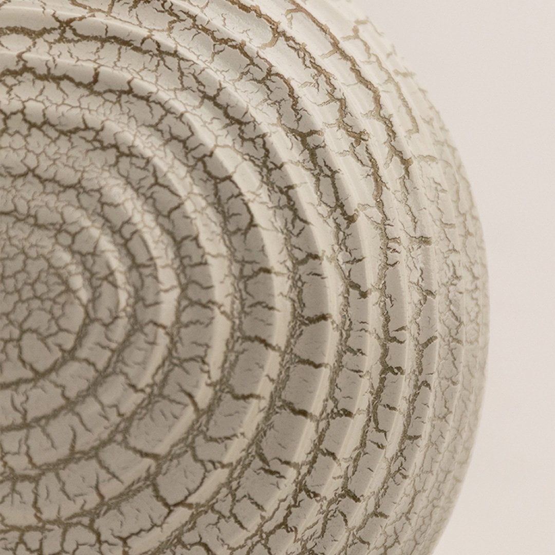 Closeup of off white ceramic sphere with crackle textured surface showing fine details and modern decorative design.