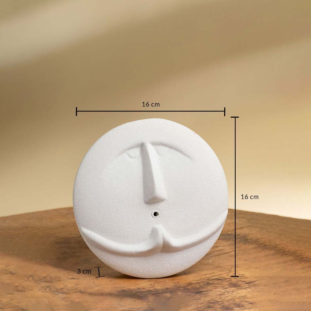 Round white face sculpture vase measuring 16 cm in height 16 cm in width and 3 cm in thickness displayed on a wooden surface.