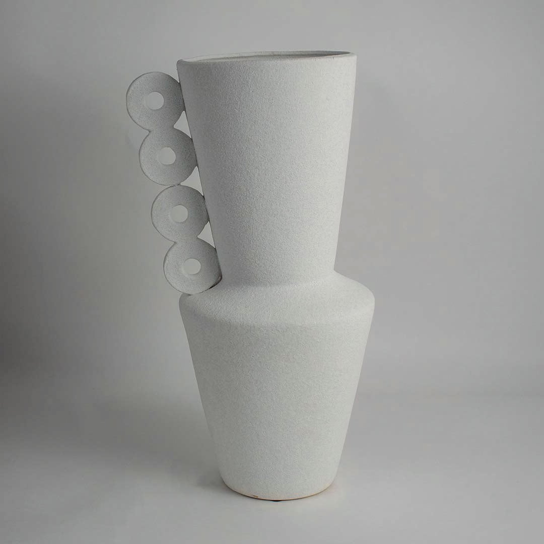 Side view of matte white ceramic vase with ring handles showing elegant sculptural silhouette and handcrafted detailing.