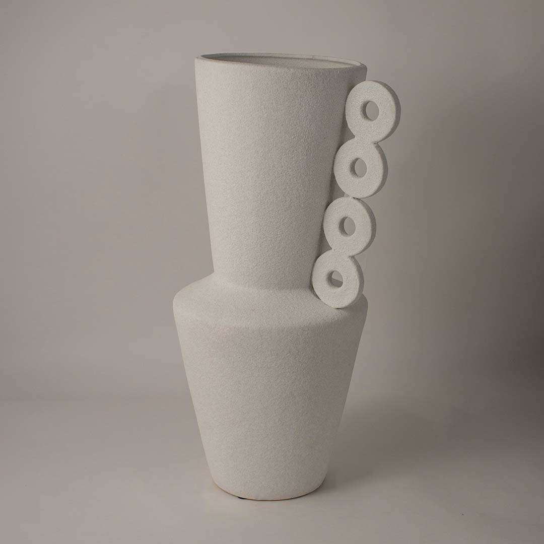 Handcrafted matte white ceramic vase featuring a ring handle design displayed against a white background for an artistic and elegant decor presentation.