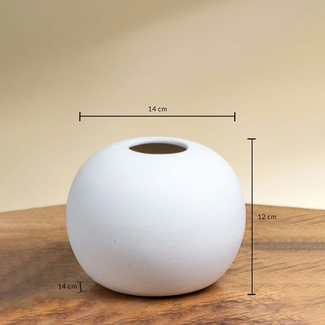 White ceramic round vase shown with 14 cm width 14 cm depth and 12 cm height on a wooden surface for accurate product measurement reference.