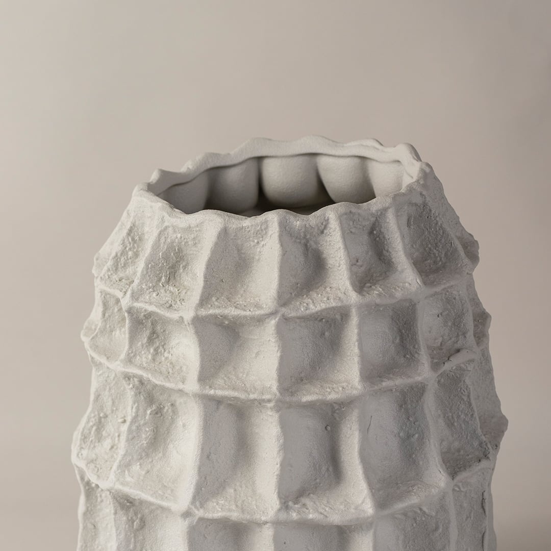 Closeup of handcrafted white ceramic vase with artistic textured finish highlighting unique sculptural detailing for home decor.