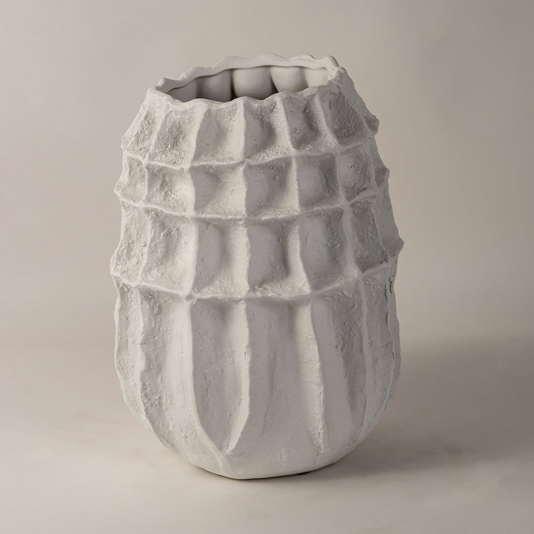 Side angle view of white textured ceramic vase with sculptural design perfect for modern interior decoration and shelf styling.