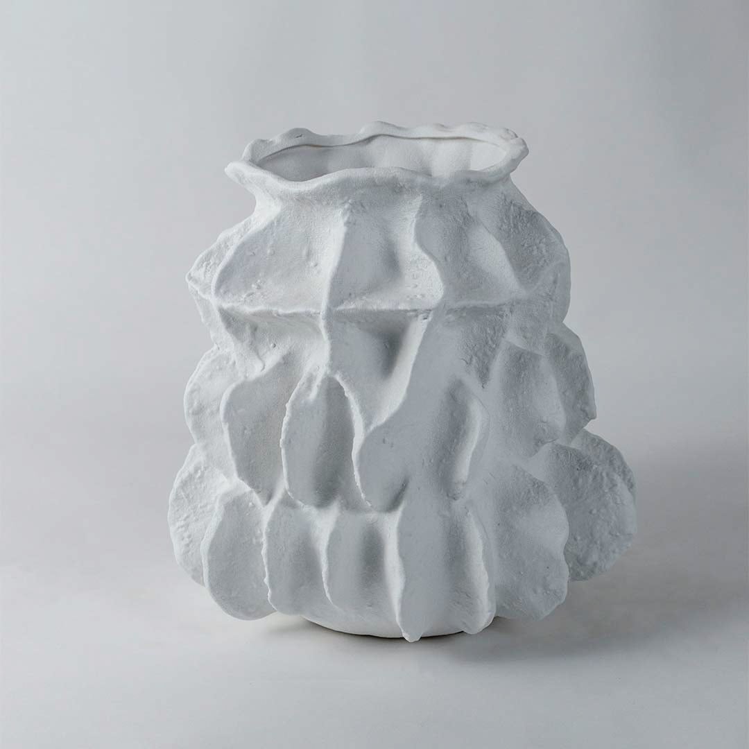 Contemporary white ceramic vase with unique sculptural form and rough textured finish ideal for modern interior decoration.