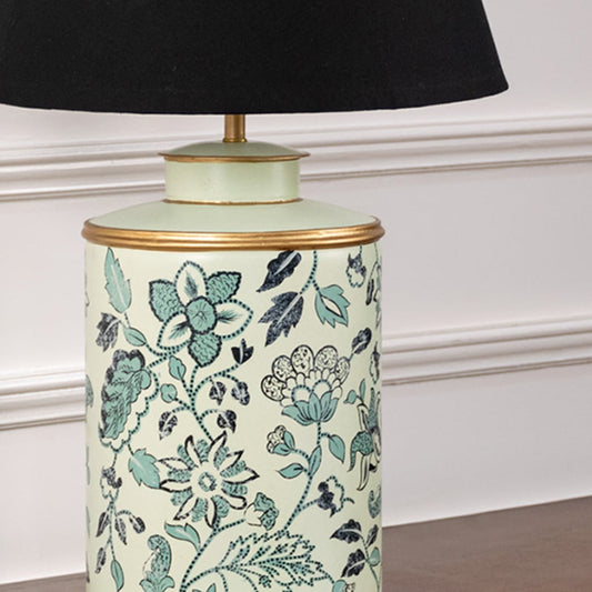Closeup of mint green floral ceramic lamp base with black shade showing delicate floral artwork and golden border detail.