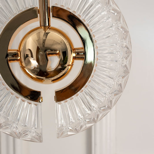 Closeup of crystal halo pendant light turned off showing intricate glass pattern and polished gold metal sphere in fine detail.