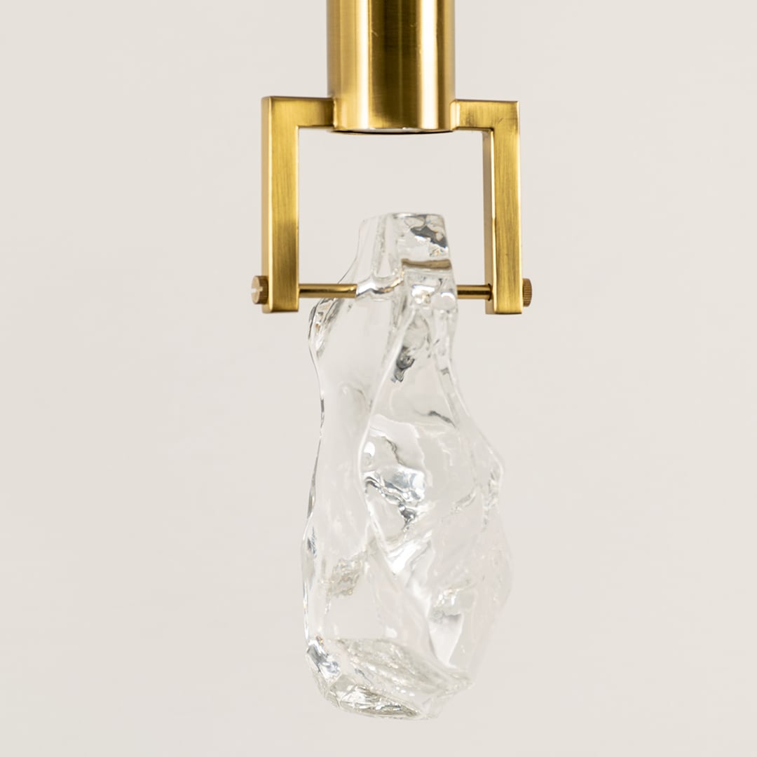 Closeup of glass pendant light showcasing premium metal fitting and textured glass surface reflecting expert craftsmanship and refined design.