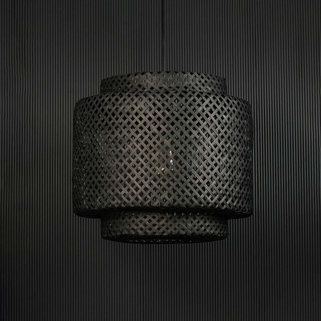 Handwoven black rattan pendant lamp highlighted on dark background ideal for rustic modern home interiors.