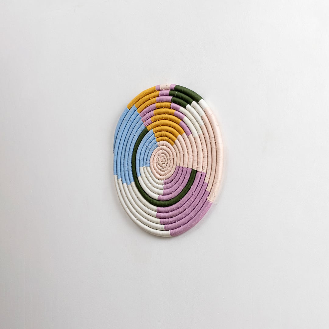 Pastel multicolor cotton wall plate in blue pink mustard green and cream shades captured from a side angle for modern artistic home wall decoration.