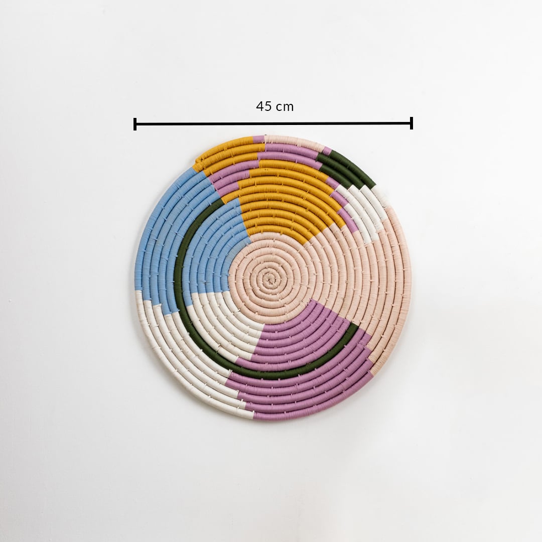 Round handwoven wall basket in soft multicolor design showing 25 cm diameter ideal for layered wall decor styling.