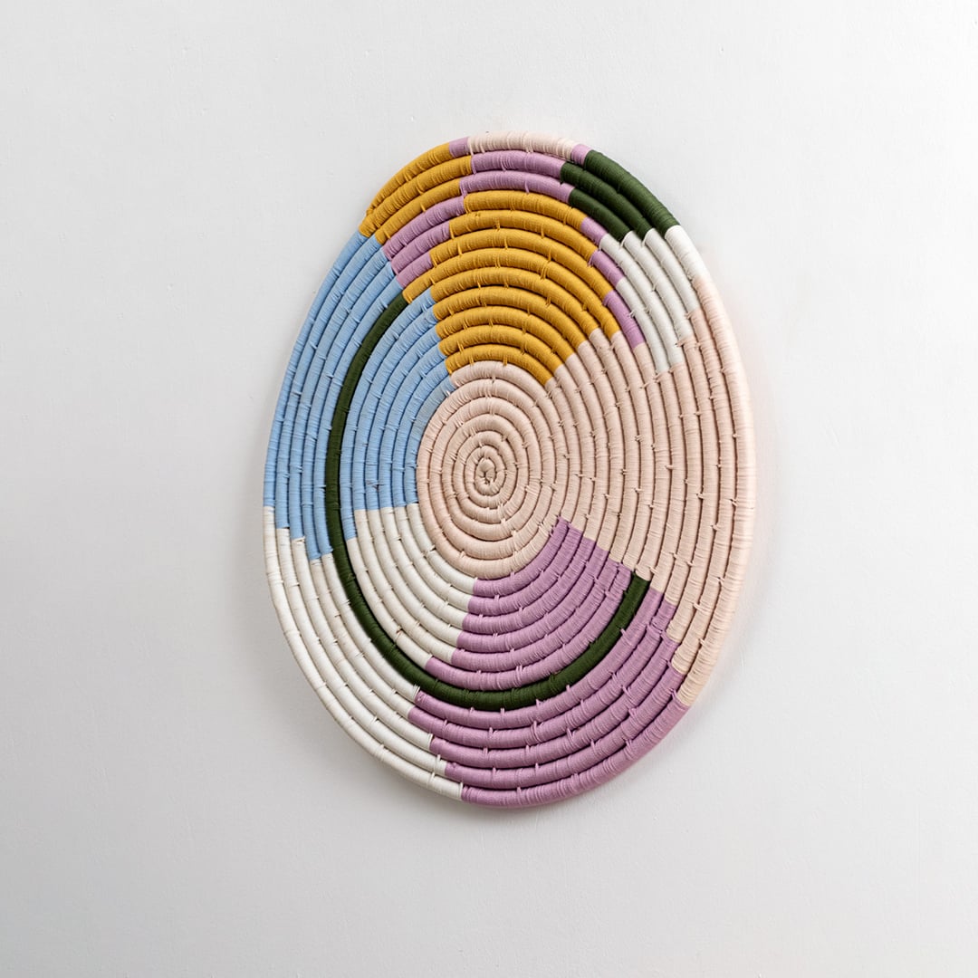 A side angle view of the woven wall plate against a white background emphasizing the raised texture and layered weaving details with rich handcrafted character.