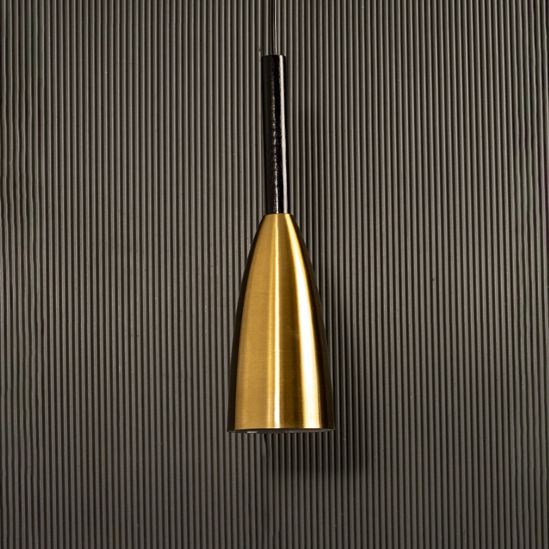 A metal pendant light glowing softly against a ribbed dark backdrop creating elegant focused illumination and minimal refined décor.