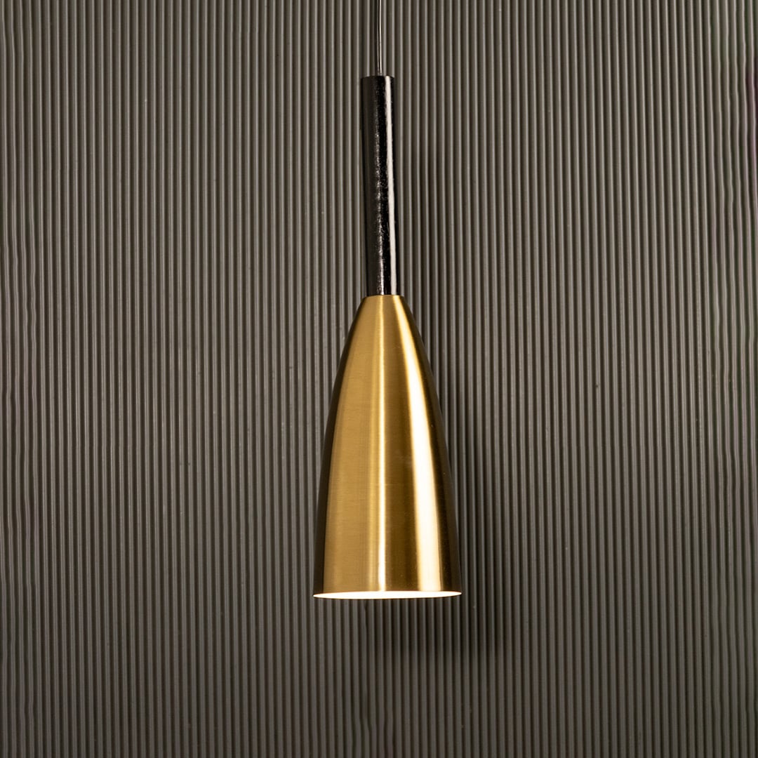 A slim metal pendant light shining softly against a ribbed dark backdrop creating elegant focused illumination and minimal refined modern décor.