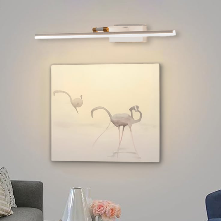 Lifestyle closeup of white and gold metal picture light enhancing artwork with warm focused gallery style illumination.