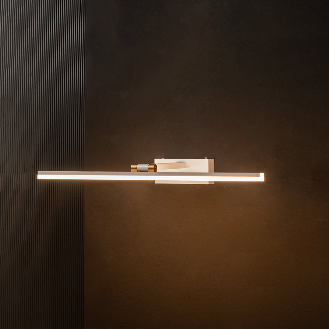 White and gold metal picture light glowing warmly on a black background creating a striking high contrast lighting effect.